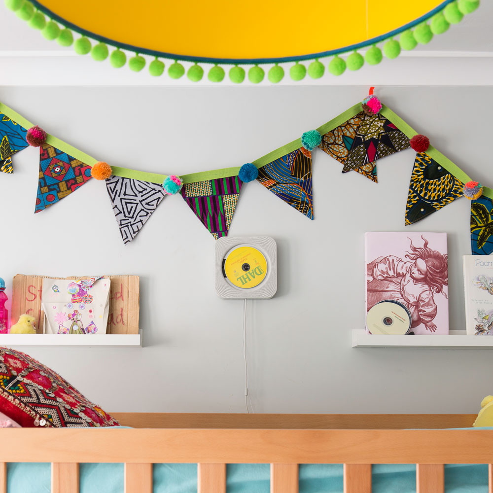 grey nursery with bright coloured pendant light and bunting