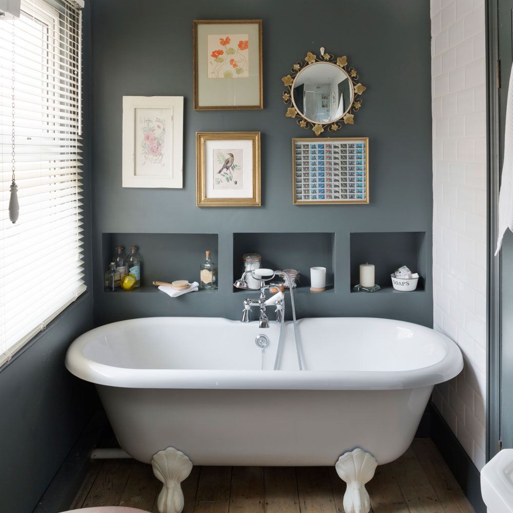 grey bathroom with gallery wall of prints and mirror above storage shelves