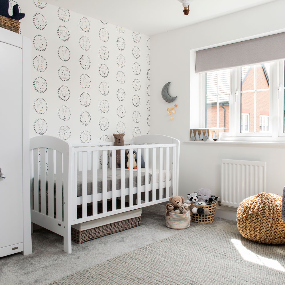 whhite and grey nursery with subtle patterned wallpaper
