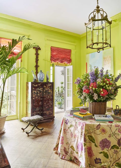 the upper salon is lime green with an octagonal table in the middle skirted in a floral tablecloth